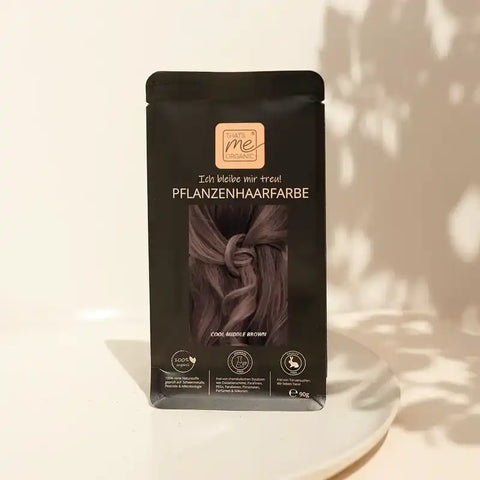 Pflanzenhaarfarbe Packung in Cool Middle Brown auf weißem Teller, natürliche Lichtstimmung