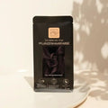 Pflanzenhaarfarbe Tüte, schwarze Verpackung, Cool Deep Mahagony Black, auf weißem Teller