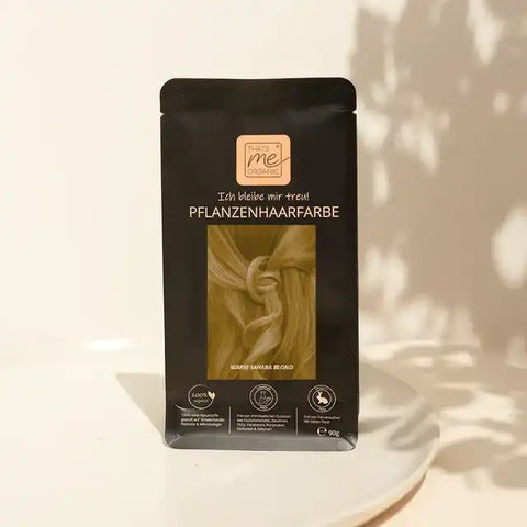 Pflanzenhaarfarbe Verpackung auf heller Unterlage, Motiv: hellblondes Haar, Bio-Produkt