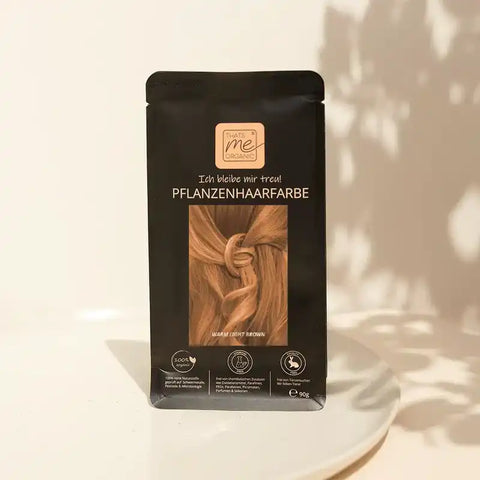 Pflanzenhaarfarbe Verpackung warmes Hellbraun, vegan, organisch, auf hellem Tisch