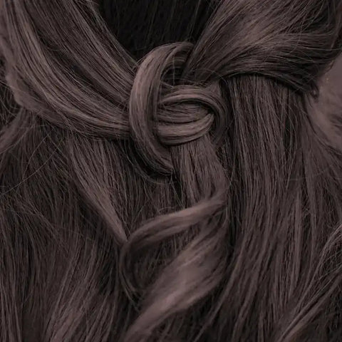 Tiefbraunes Haar, glänzend und glatt, kunstvoll zu einem Knoten gestylt