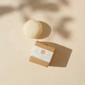 Festes Shampoo vegan in Papierverpackung und Shampoo Bar auf beigem Hintergrund