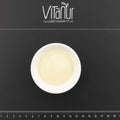 Weiße Schale mit Bio Ziegen Ghee auf schwarzer Unterlage mit Vitanu Logo und Maßstab