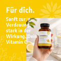 Vitalove Vitamin C Kapseln in der Hand mit Zitronen-Hintergrund