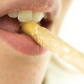 Nahaufnahme einer Person, die eine Miswak Zahnbürste zum Zähneputzen verwendet