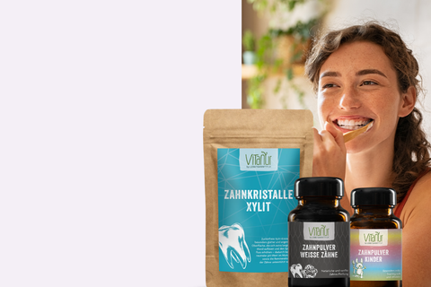 Frau putzt Zähne mit Holzbürste neben Vitalür Zahnkristalle Xylit und Zahnpulver