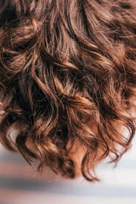 Nahaufnahme von braunem lockigem Haar, natürlich, gesund, Frisuren Inspiration